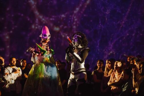 Two drag queens dancing in the center of a crowd of people in the Adler's "Grainger Sky Theater."