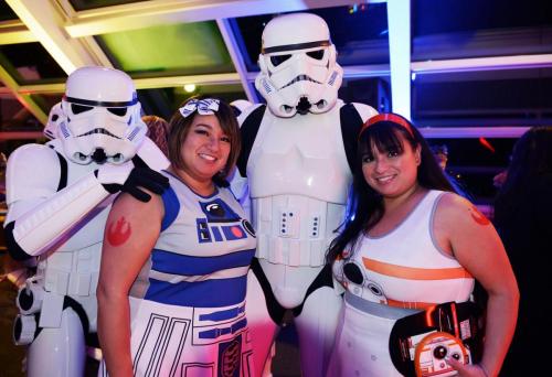 An image of two "Adler After Dark" guests dressed in Star Wars cosplay, and posing with two stormtroopers.