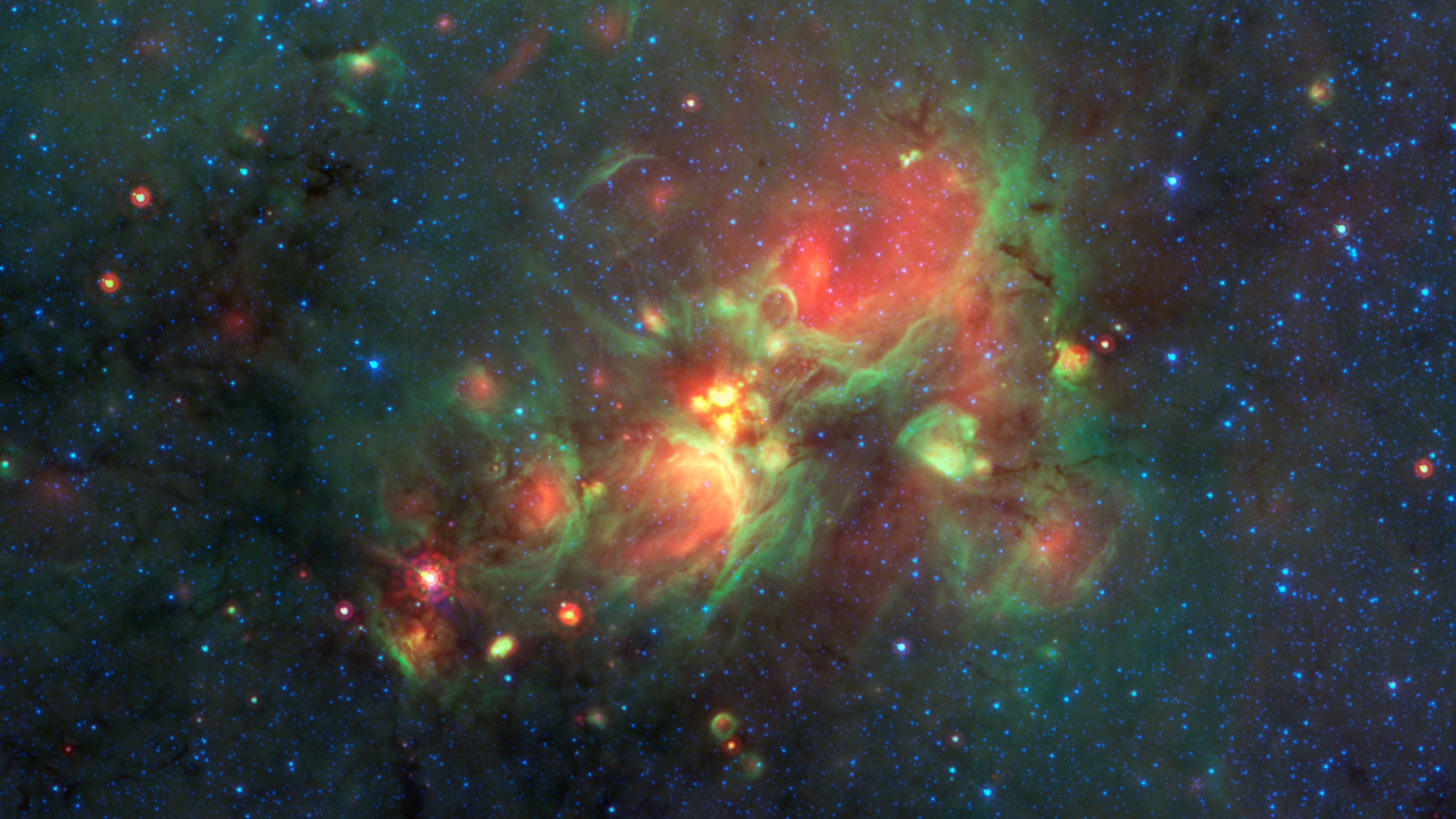 Volunteers using the web-based Milky Way Project brought star-forming features nicknamed "yellowballs" to the attention of researchers, who later showed that they are a phase of massive star formation. The yellow balls -- which are several hundred to thousands times the size of our solar system -- are pictured here in the center of this image taken by NASA's Spitzer Space Telescope. Infrared light has been assigned different colors; yellow occurs where green and red overlap. The yellow balls represent an intermediary stage of massive star formation that takes place before massive stars carve out cavities in the surrounding gas and dust (seen as green-rimmed bubbles with red interiors in this image). Infrared light of 3.6 microns is blue; 8-micron light is green; and 24-micron light is red.